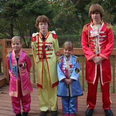 three children in costumes standing on a deck