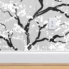 an electrical outlet cover with a black and white painting of a tree on the wall