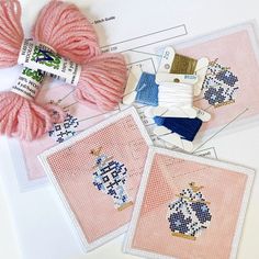 three cross stitch cards and two skeins of yarn