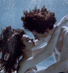 a man and woman under water in the ocean