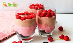 raspberry trifle desserts in glasses with strawberries on the table next to them