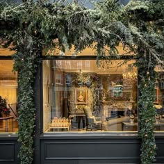 a store front with greenery on the outside