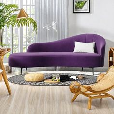 a living room with purple couches and wooden chairs in the middle of the room