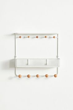 a white wall mounted shelf with wooden balls on it