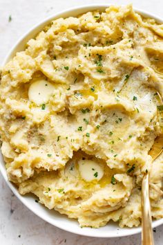 a bowl filled with mashed potatoes topped with parsley