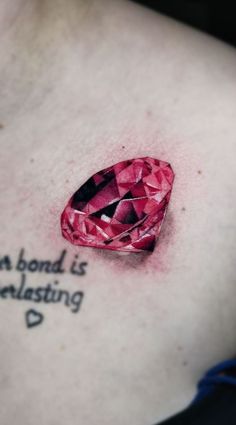 a woman's chest with a pink diamond tattoo on it