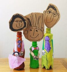 three children's handmade bottles sitting on top of a wooden table