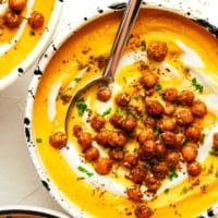 two bowls filled with soup and garnished with meatballs