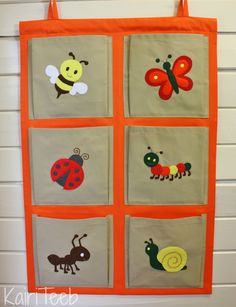 an orange and gray wall hanging with pictures of bugs, ladybugs, and butterflies