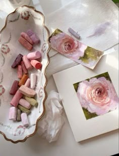 some pink flowers are on a white plate and there is a small card next to it