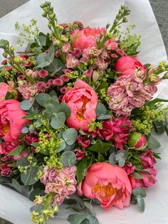 a bouquet of pink flowers sitting on top of a white tablecloth covered table cloth