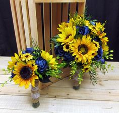 two vases filled with sunflowers and blue flowers on a wooden table next to a chair