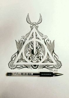 a pen is sitting on top of a triangle with an image of a demon in it