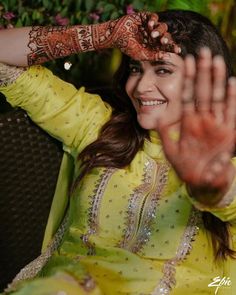 a woman wearing a yellow outfit and holding her hands up