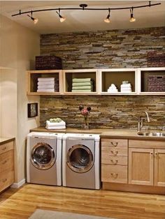 a washer and dryer in a room with wood floors, cabinets and shelves