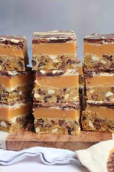 several pieces of dessert sitting on top of a wooden cutting board next to each other