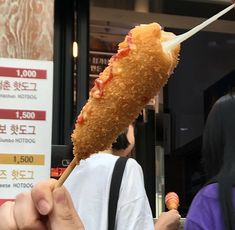 a person holding up a piece of food on a stick