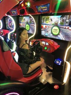 a woman sitting in front of a tv playing a video game