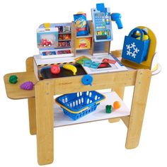 a child's play table with toys on it and a shopping bag in the center