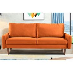 an orange couch sitting in front of a window