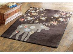 a rug with an image of a moose and flowers on it in a living room