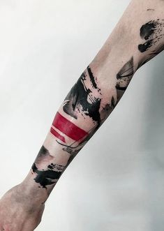 a man's arm with black and red ink splattered on the top