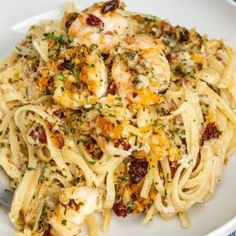 a white plate topped with pasta and shrimp