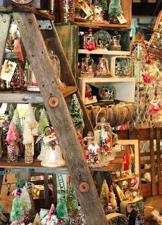 an old ladder is used as a christmas display in a store filled with holiday decorations