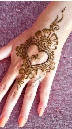 a woman's hand with hennap on it and a heart in the middle