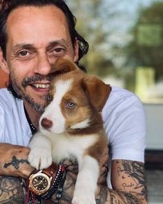 a man holding a puppy in his arms with the caption marc anthony papasito