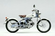 a white and blue motorcycle parked on top of a white floor