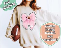 Show your team spirit with this Custom Football Bow Sweatshirt, perfect for football fans, cheerleaders, and sports enthusiasts. 🏈 Customize it with your team's cheer and mascot icon for a truly unique piece. Personalized Design: Add your team's cheer around the bow and a custom mascot icon on the bow. High-Quality Material: Made from soft, comfortable fabric that's perfect for chilly game days. Perfect Gift: Ideal for football fans, cheerleaders, or as a thoughtful gift for sports enthusiasts. Variety of Sizes: Available in multiple sizes to ensure the perfect fit for everyone. Durable and Stylish: Designed to last with vibrant prints and a stylish look. Get ready to cheer on your team in style with this one-of-a-kind sweatshirt! .: Made with a medium-heavy fabric blend of 50% cotton and Varsity Tops For Cheerleading, Football Season, Varsity Style Top For Cheerleading And Football Season, Football Season Cheerleading Tops With Team Logo, Cheerleading Team Logo Tops For Football Season, Football Season Sweatshirt For School Spirit, Cheerleading Tops With Team Name For Football Season, Team Spirit Sweatshirt For Football Season, Football Season Sweatshirt For Sports Events, Sporty Sweatshirt For Football Season Cheerleading