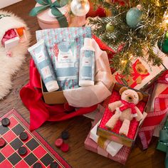 a christmas tree with gifts and a teddy bear