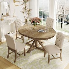 a dining room table with chairs and a vase on top of it in front of a fireplace