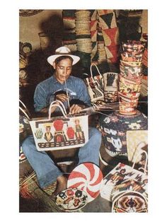 a man sitting on the floor surrounded by baskets and other decorative items, with a basket in front of him