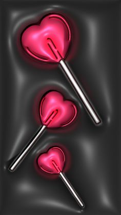 two heart shaped lollipops on a black background