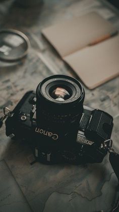 a camera sitting on top of a map next to a pen and eyeglasses