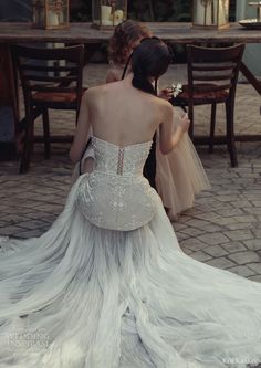 the back of a woman's dress as she sits at a table with two other women