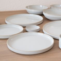 a table topped with white plates and bowls