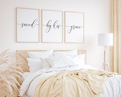 a bedroom with two framed pictures above the bed and pillows on the bed, next to a plant