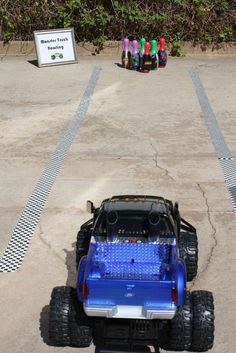 a blue toy truck parked on top of a parking lot