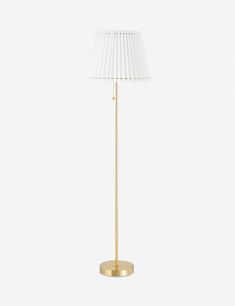 a gold floor lamp with a white shade