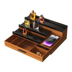 an open wooden drawer with two bottles and one cell phone on it