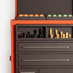 an orange and black cabinet with drawers