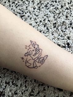 a small tattoo on the leg of a person with an unicorn and stars around it