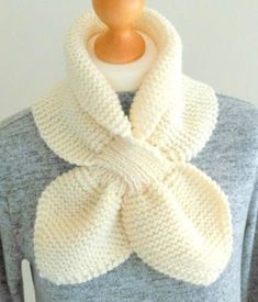 a white knitted scarf on top of a mannequin