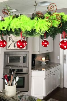 a kitchen decorated for christmas with ornaments hanging from the ceiling