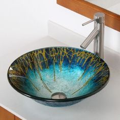 a glass bowl sink sitting on top of a white counter next to a faucet