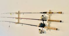 three fishing rods are hanging on the wall