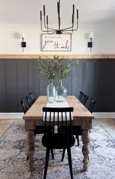 a dining room table with two vases on it and some chairs around the table